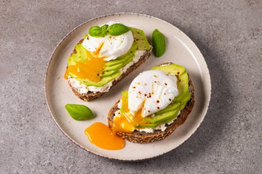Avokado, krem peynirli tost çavdar ekmeği ve haşlanmış yumurta. Sağlıklı kahvaltı konsepti için açık sandviç..