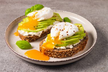 Avokado, krem peynirli tost çavdar ekmeği ve haşlanmış yumurta. Sağlıklı kahvaltı konsepti için açık sandviç..