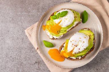 Avokado, krem peynirli tost çavdar ekmeği ve haşlanmış yumurta. Sağlıklı kahvaltı konsepti için açık sandviç..