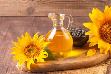 Geleneksel ahşap arka planda ayçiçeği yağı ve ayçiçeği tohumları. Organik ve ekolojik gıda konsepti. Sağlıklı yiyecekler ve yağlar.