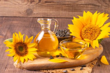 Sunflower oil and sunflower seeds on traditional rustic wooden background. Organic and eco food concept. Healthy food and fats.