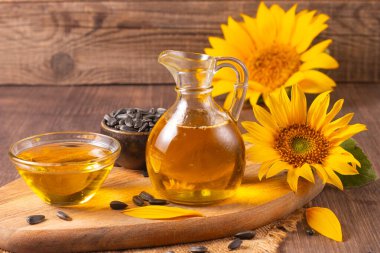Geleneksel ahşap arka planda ayçiçeği yağı ve ayçiçeği tohumları. Organik ve ekolojik gıda konsepti. Sağlıklı yiyecekler ve yağlar.