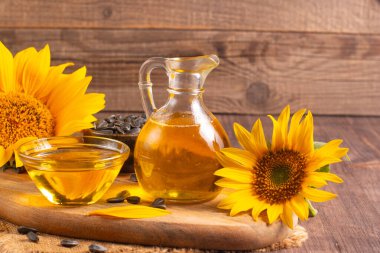 Sunflower oil and sunflower seeds on traditional rustic wooden background. Organic and eco food concept. Healthy food and fats.