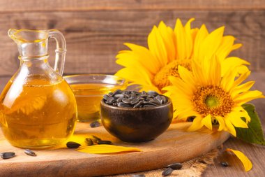 Geleneksel ahşap arka planda ayçiçeği yağı ve ayçiçeği tohumları. Organik ve ekolojik gıda konsepti. Sağlıklı yiyecekler ve yağlar.