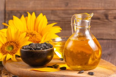 Geleneksel ahşap arka planda ayçiçeği yağı ve ayçiçeği tohumları. Organik ve ekolojik gıda konsepti. Sağlıklı yiyecekler ve yağlar.