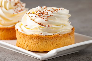 Krem şantili limonlu turtalar, beyaz arka planda çikolata parçaları.