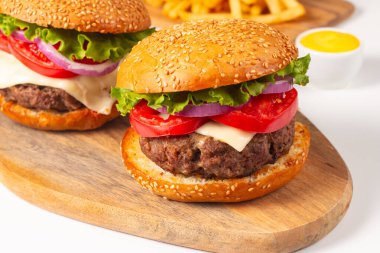 Sığır eti, soğan, domates, marul, peynir ve baharattan yapılmış hamburger. Taze burger yakın plan. Çizburger..