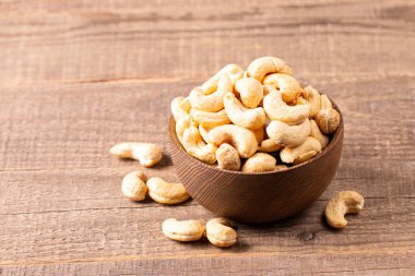 Ahşap bir kasede organik kavrulmuş kaju fıstığı. Üst görünüm. 