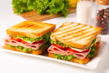 Jambonlu sandviç, peynirli, domatesli ve marullu.