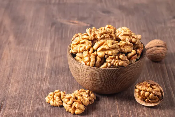 Ahşap arka planda bir kasede ceviz