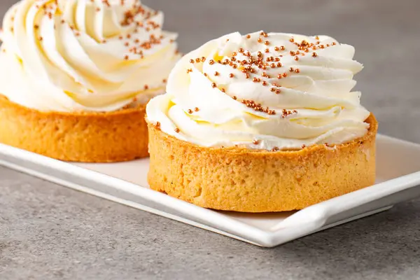 Krem şantili limonlu turtalar, beyaz arka planda çikolata parçaları.