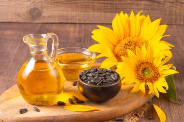 Geleneksel ahşap arka planda ayçiçeği yağı ve ayçiçeği tohumları. Organik ve ekolojik gıda konsepti. Sağlıklı yiyecekler ve yağlar.