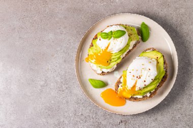 Avokado, krem peynirli tost çavdar ekmeği ve haşlanmış yumurta. Sağlıklı kahvaltı konsepti için açık sandviç.