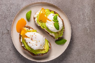 Avokado, krem peynirli tost çavdar ekmeği ve haşlanmış yumurta. Sağlıklı kahvaltı konsepti için açık sandviç.