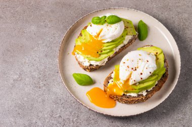 Avokado, krem peynirli tost çavdar ekmeği ve haşlanmış yumurta. Sağlıklı kahvaltı konsepti için açık sandviç.
