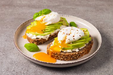 Avokado, krem peynirli tost çavdar ekmeği ve haşlanmış yumurta. Sağlıklı kahvaltı konsepti için açık sandviç.