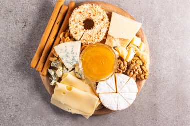 Çeşitli peynirler ve zeytinlerle ahşap şarküteri tahtası. Krem peynir. Camembert peyniri. Parmesan, feta, mavi peynir. İtalyan, Fransız peyniri