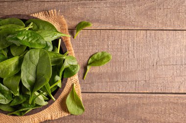 Tahta arka planda yeşil ıspanak yaprakları. Organik gıda konsepti. 