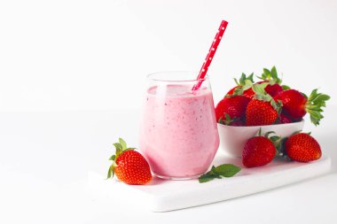 Beyaz arka planda bir bardak taze çilekli smoothie. Yaz içeceği, milkshake ve ferahlatıcı organik konsept..