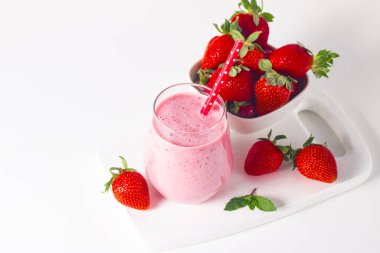 Beyaz arka planda bir bardak taze çilekli smoothie. Yaz içeceği, milkshake ve ferahlatıcı organik konsept..