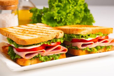 Jambonlu sandviç, peynirli, domatesli ve marullu.