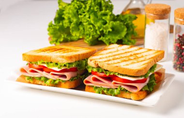 Jambonlu sandviç, peynirli, domatesli ve marullu.