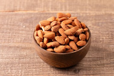 Kahverengi ahşap kasede çiğ badem. Organik gıda konsepti. 