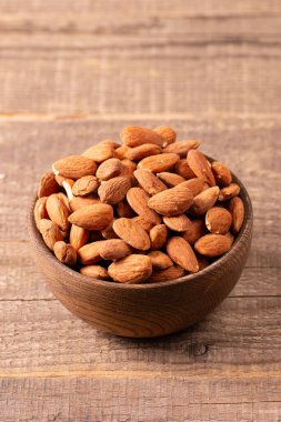Kahverengi ahşap kasede çiğ badem. Organik gıda konsepti. 