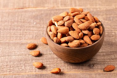Kahverengi ahşap kasede çiğ badem. Organik gıda konsepti. 