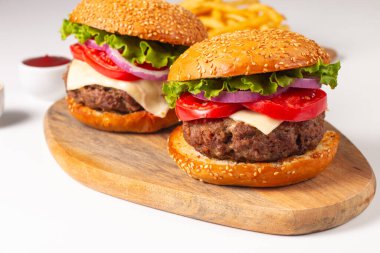 Sığır eti, soğan, domates, marul, peynir ve baharattan yapılmış hamburger. Taze burger yakın plan. Çizburger..