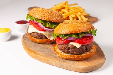 Sığır eti, soğan, domates, marul, peynir ve baharattan yapılmış hamburger. Taze burger yakın plan. Çizburger..
