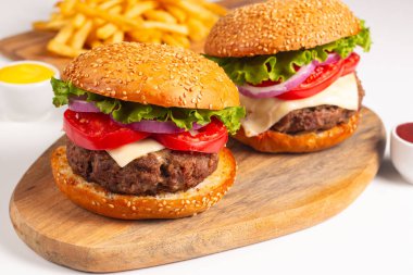 Sığır eti, soğan, domates, marul, peynir ve baharattan yapılmış hamburger. Taze burger yakın plan. Çizburger..