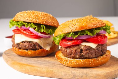 Sığır eti, soğan, domates, marul, peynir ve baharattan yapılmış hamburger. Taze burger yakın plan. Çizburger..