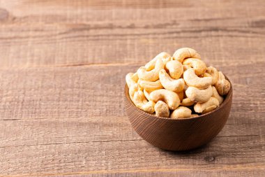 Ahşap bir kasede organik kavrulmuş kaju fıstığı. Üst görünüm. 