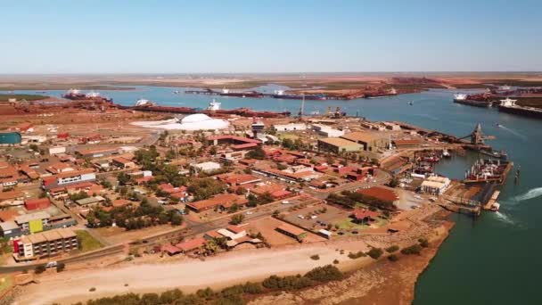 西オーストラリア州ポートヘッドランドの乾燥した赤いオーストラリアの風景に囲まれた忙しい出荷ポートの空中ショット — ストック動画