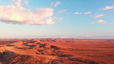 Uzak Avustralya çöllerinde mavi gökyüzü olan büyük kırmızı kum tepelerinin insansız hava aracı görüntüleri.