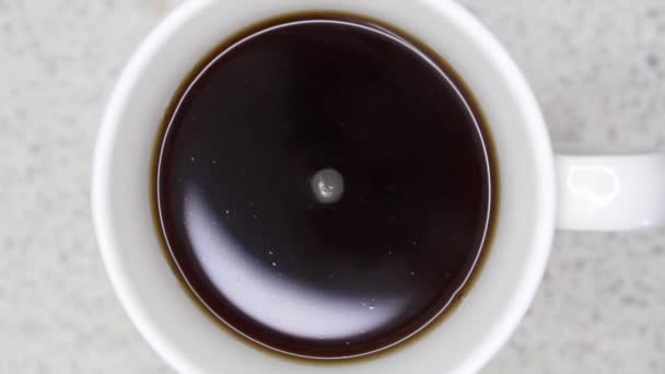 黑咖啡慢慢地在杯子里旋转 环绕着视频 顶部向下 — 图库视频影像