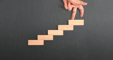 Oyuncak merdiven tahtasına tırmanan el yapımı bir insan.