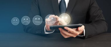 Akıllı telefon aygıtı tutan ve beş yıldız derecelendirme geri besleme simgesi ile ekrana dokunan adam