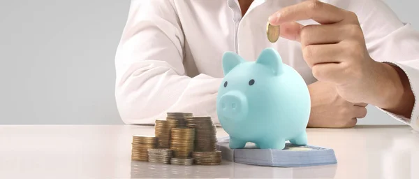 Man hand put coin money to piggy bank, saving and deposit money concept