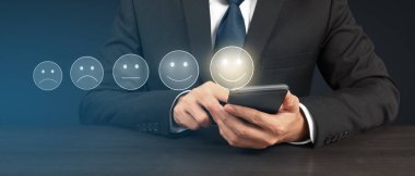 Akıllı telefon aygıtı tutan ve beş yıldız derecelendirme geri besleme simgesi ile ekrana dokunan adam