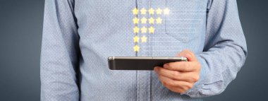 Akıllı telefon aygıtı tutan ve beş yıldız derecelendirme geri besleme simgesi ile ekrana dokunan adam