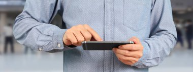 Akıllı telefon aygıtı tutan ve ekrana dokunan adam