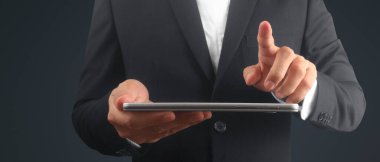 Ellerinde tablet, dokunmatik bilgisayar aleti var.