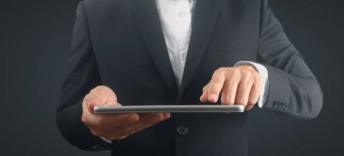 Ellerinde tablet, dokunmatik bilgisayar aleti var.