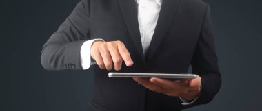 Ellerinde tablet, dokunmatik bilgisayar aleti var.