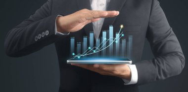 İşadamı, elinde tabletle iş yerinde grafik büyümesi ve grafik artışı planlıyor
