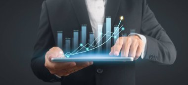 İşadamı, elinde tabletle iş yerinde grafik büyümesi ve grafik artışı planlıyor