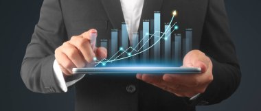 İşadamı, elinde tabletle iş yerinde grafik büyümesi ve grafik artışı planlıyor