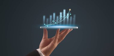 İşadamı, elinde tabletle iş yerinde grafik büyümesi ve grafik artışı planlıyor